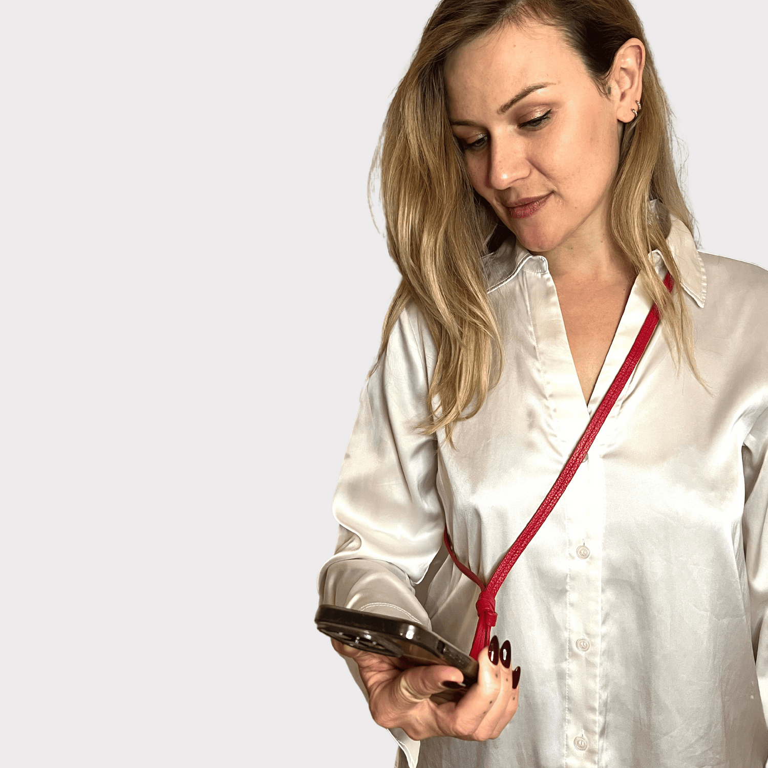 Rotes, flaches Lederhandyband mit Karabinerhaken, ideal für sicheren und stilvollen Transport von Handy, Schlüssel und Mini-Wallet.