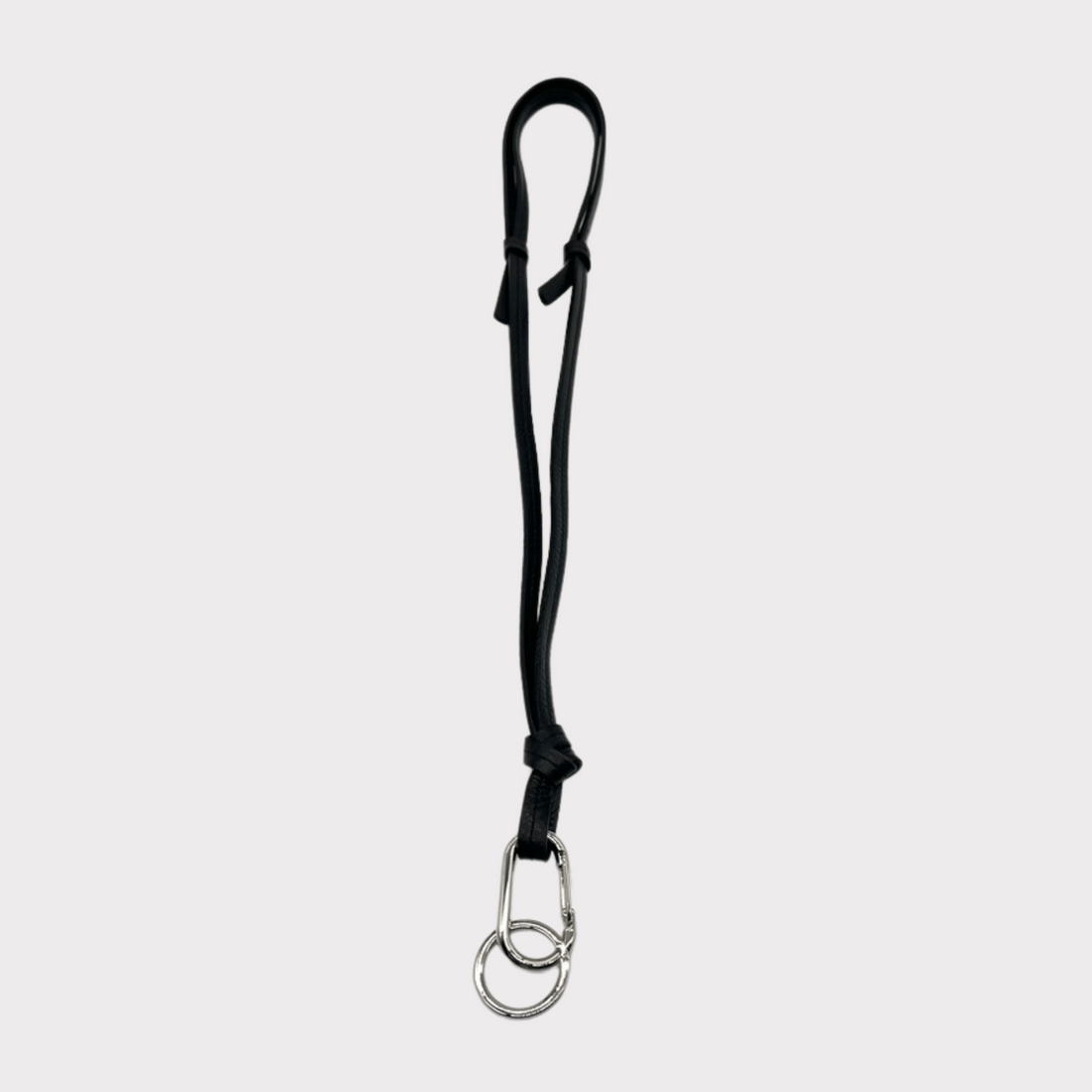 Hochwertiges schwarzes Leder-Schlüsselband, das auch als Crossbody-Tragegurt verwendet werden kann. Es ist mit einem silbernen Karabinerhaken und Schlüsselring ausgestattet, an dem ein Mini-Wallet, Schlüssel und Handy sicher befestigt werden können. Das stilvolle und praktische Accessoire ist ideal für unterwegs.