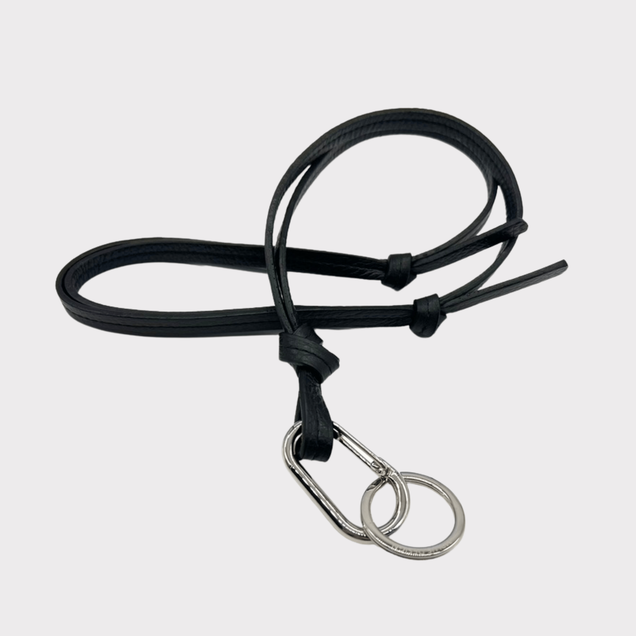 Hochwertiges schwarzes Leder-Schlüsselband, das auch als Crossbody-Tragegurt verwendet werden kann. Es ist mit einem silbernen Karabinerhaken ausgestattet, an dem ein Mini-Wallet, Schlüssel und Handy sicher befestigt werden können. Das stilvolle und praktische Accessoire ist ideal für unterwegs.