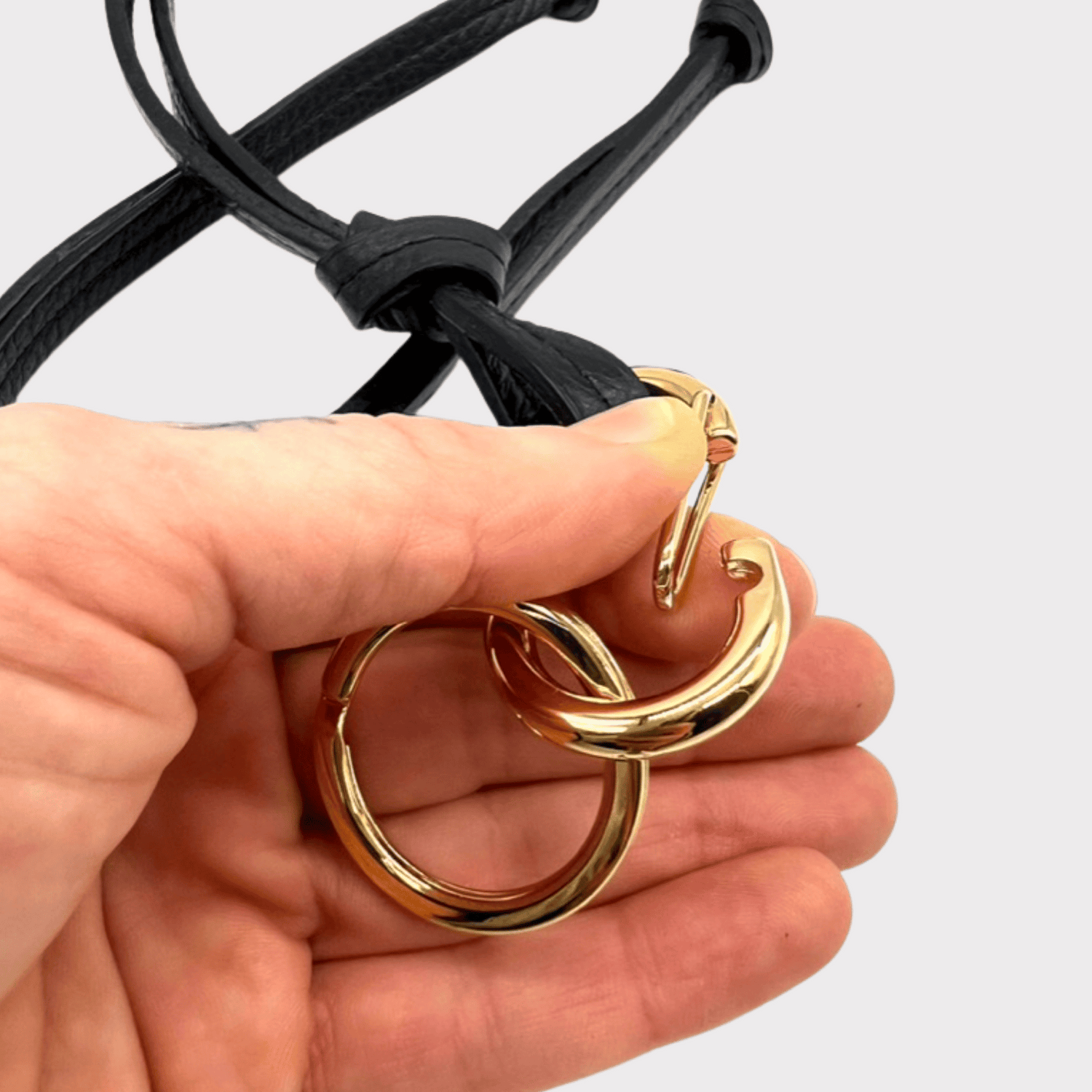 Detailansicht der Schnappringe und Karabiner des Sonnenbrillen Cases in gold, die ein einfaches Abnehmen ermöglichen